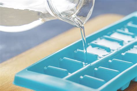 These are the best ice cube trays ever! Pouring Water Into Ice Cube Tray On The Kitchen Table ...