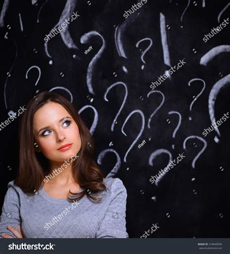 Young Girl With Question Mark On A Gray Background Stock Photo