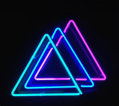 Three Neon Signs Sitting Next To Each Other In The Dark