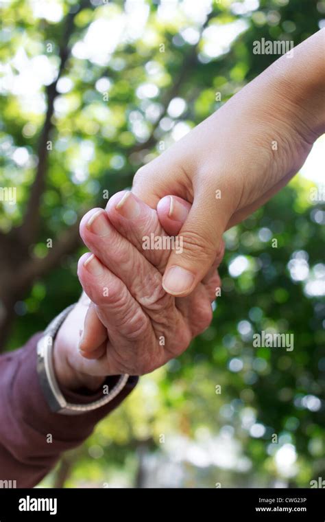 Senior Woman Holding Hands With Her Caretaker Outside Stock Photo Alamy