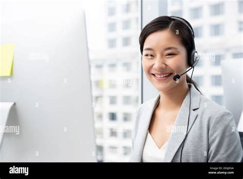 Smiling Beautiful Asian Woman Working In Call Center City Office As A Customer Service Operator