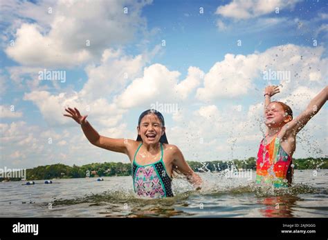Zwei junge Mädchen in Badeanzügen planschen in einem See Stockfotografie Alamy