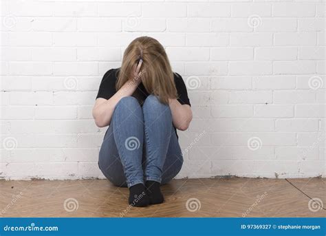 Worried And Upset Female Sitting With Her Head In Her Hands Stock Image