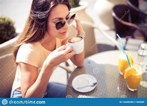 Young Pretty Woman Drinking Cappuccino Coffee In Cafe Outdoors Stock