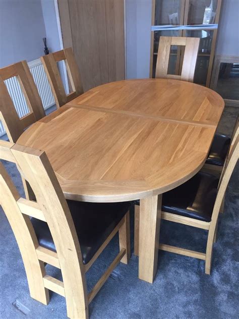 oak dining room table and chairs Hudson round oak extending dining table with 4 duke grey velvet chairs