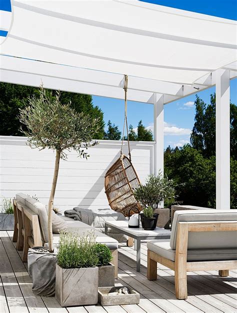 An Outdoor Living Area With White Walls And Wooden Floors Covered By A