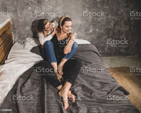 Two Beautiful Women Enjoy Communication In Each Others Arms While Lying