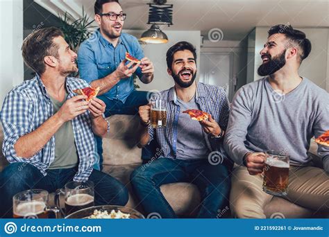 positive male friends drinking beer and eating pizza at home stock image image of expression