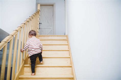 Toddler Boy Walking Up Stairs At Home Stock Photo