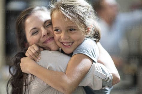 Mother And Daughter Cuddling And Embracing Stock Photo