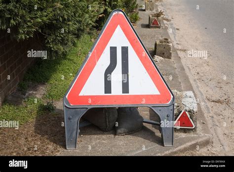 Red Triangular Sign Warning Of Road Narrowing Ahead Uk Stock Photo Alamy