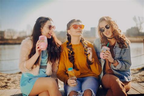 Three Girls Sit On The Beach Near The River Talk Gossip Joke Laugh Smile At Womans Day