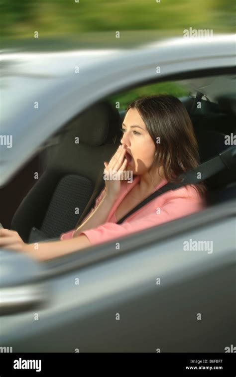 Young Woman Looking Tired And Yawning While Sitting In The Drivers Seat