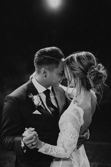 Black And White Photo Of Bride And Groom Hugging Each Other In Front Of A Spotlight