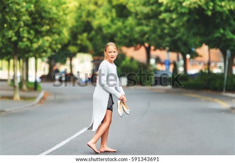 Photo De Stock Little Barefoot Girl Walking Down Street 591343691