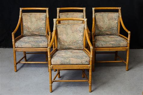 The back displays an upholstered backrest and the seat features a loose cushion that rests on a stick deck (shown). Set of 4 McGuire Rattan Target (M-59U) Armchairs with ...