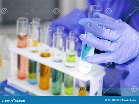 The Scientist`s Hand Holds A Beaker Of Chemicals In The Lab To Prepare