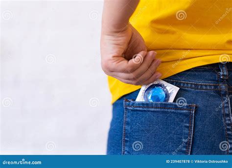 The Girl Puts A Blue Condom In The Pocket Of Her Blue Jeans With Her