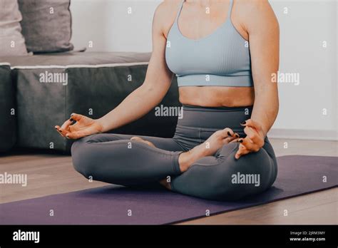 close up hands of woman doing yoga lotus pose and meditating at her home in living room body