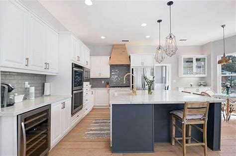 A white subway tile backsplash adds a. Kitchen with white cabinets, dark gray island marble ...