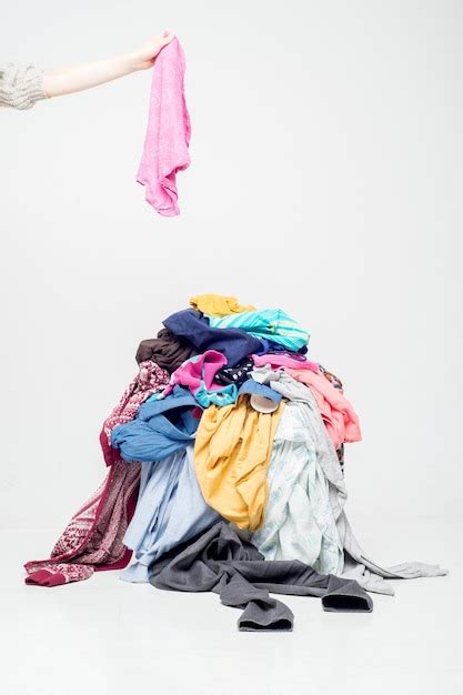 Premium Photo Hand Throws Clothes Into A Pile With Used Clothes Pile