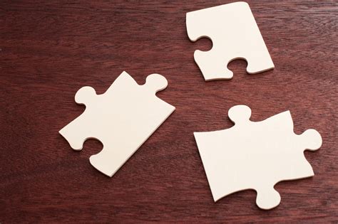 Free Stock Photo 12737 Three blank puzzle pieces over brown table | freeimageslive