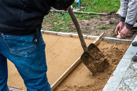 Premium Photo Worker Screeding Sand Bedding To Level For Laying