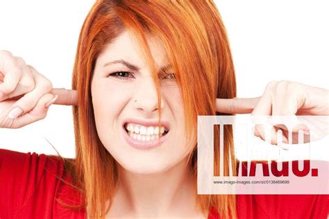 Picture Of Unhappy Redhead Woman With Fingers In Ears