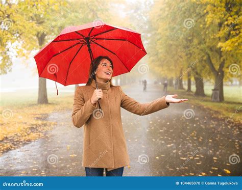 Happy Woman With Red Umbrella Walking At The Rain In Beautiful Autumn