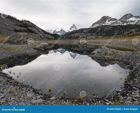 Prominent Peak Reflecting In The Alpine Lake During Overcast Day Mt