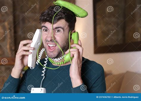 Messy Man Using Two Landline Telephones At The Same Time Stock Photo