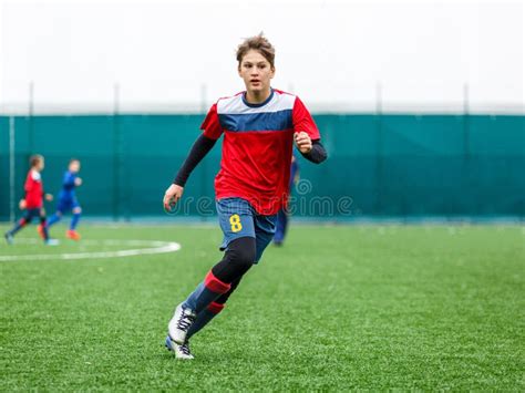 Football Training For Kids Boys In Blue Red Sportswear On Soccer Field