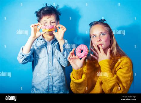 La Famiglia Felice Del Fratello E Sorella Di Mangiare Le Ciambelle Su Sfondo Blu Lo Stile Di