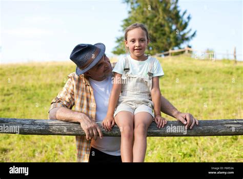 Portrait Of Grandfather And Granddaughter By Fence Stock Photo Alamy