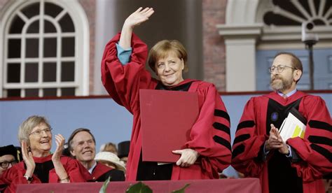 German Chancellor Angela Merkel Center Waves As She Is Presented With