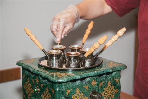 Woman Makes Turkish Coffee On A Coffee Machine With Sand In Cezve