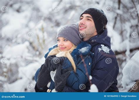 Happy Couple Having Fun And Embracing Outdoors In Snow Park Winter