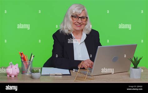 Smiling Professional Mature Business Woman Opening Laptop Computer At