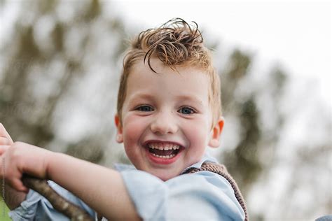 Portrait Of A Cute Young Boy Preschooler Smiling In A Field By