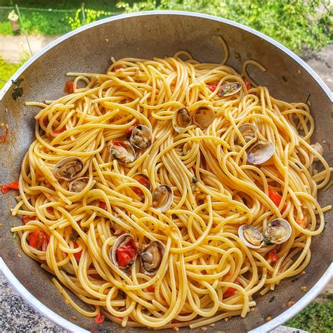 Amalgama gli ingredienti con i molluschi sgusciati e impiatta i tuoi magnifici spaghetti alle vongole! Spaghetti alle Vongole con Pomodorino - Piatti Tipici