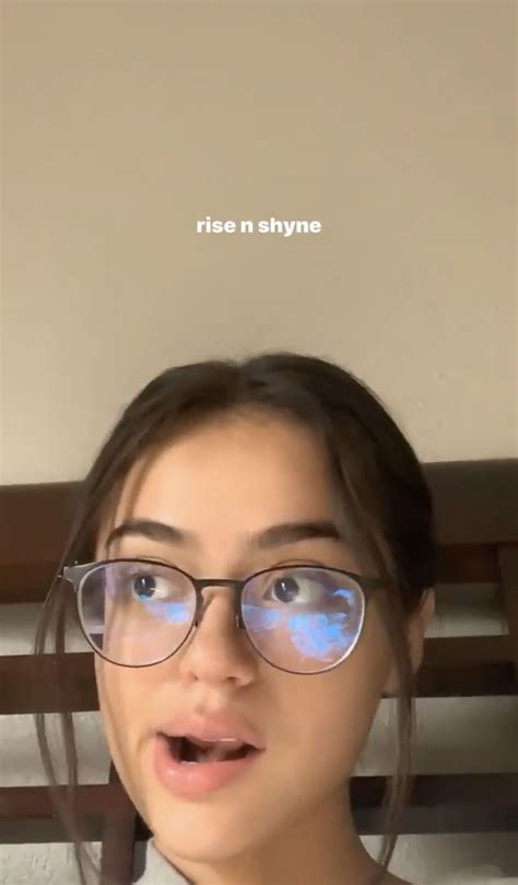 a woman wearing glasses with the words rise n shine on her face behind her