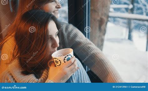 Happy Young Caucasian Women Sitting Near The Window And Drinking Coffee Lesbian Couple