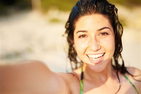 Cheerful Woman Taking Selfie On Beach By Guille Faingold