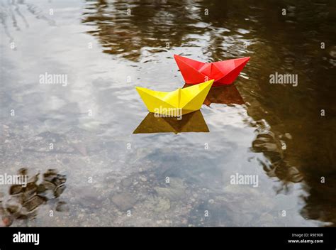 Two Multicolored Paper Boats Floating On A Stream Outdoor On Autumn Day