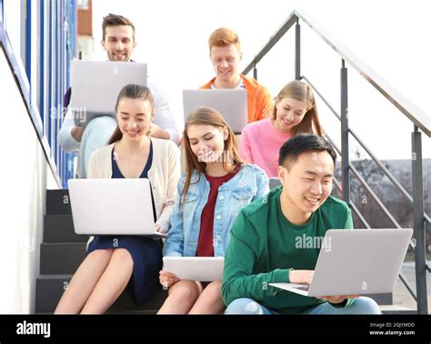 Young People With Gadgets Sitting On Stairs Outdoor Stock Photo Alamy