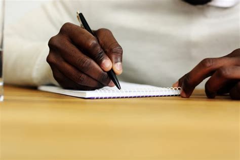 Closeup Portrait Of A Male Hand Writing On A Paper News With Attitude