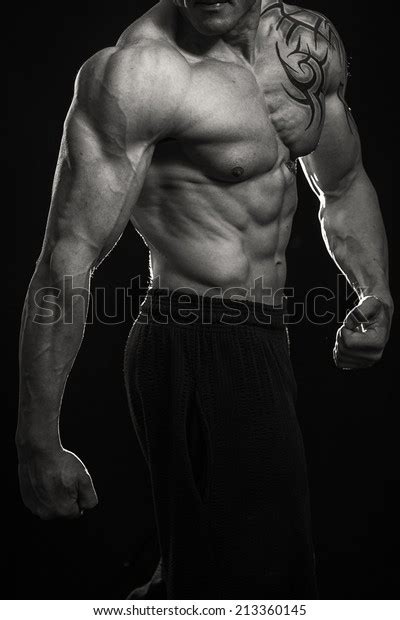 Muscular Man Bodybuilder With Tattoos Man Posing On A Black Background
