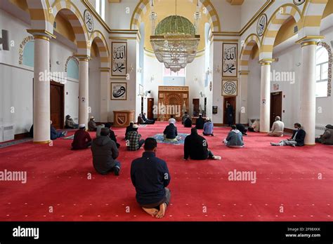 a group of muslim men gather for early afternoon prayers on the ground floor of the bosniak
