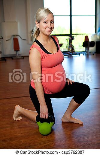 Pregnant Woman Exercising With A Kettlebell A Pregnant Woman Doing