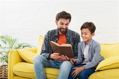 Padre E Hijo Leyendo Un Libro Foto Gratis